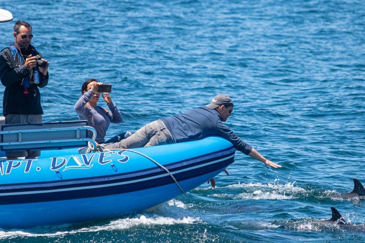 a person riding on the back of a boat in a body of water